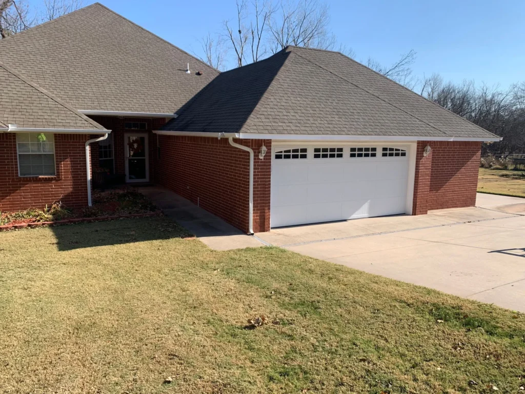 white garage door on brick home - garage door company service areas near you